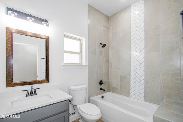 full bathroom featuring tiled shower / bath, vanity, and toilet