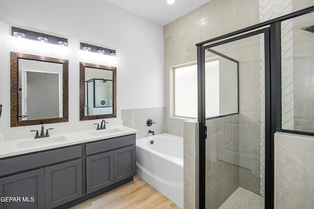 bathroom featuring wood-type flooring, vanity, and plus walk in shower