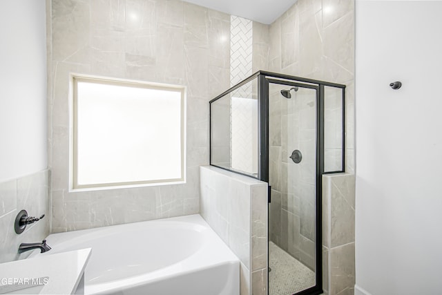 bathroom with vanity and separate shower and tub