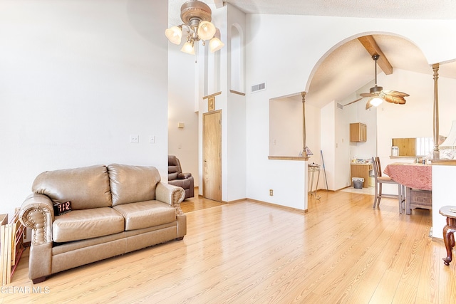 living room with high vaulted ceiling, beam ceiling, light hardwood / wood-style flooring, and ceiling fan