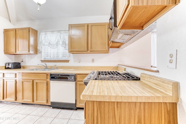 kitchen with lofted ceiling, sink, light tile patterned floors, dishwasher, and light brown cabinetry