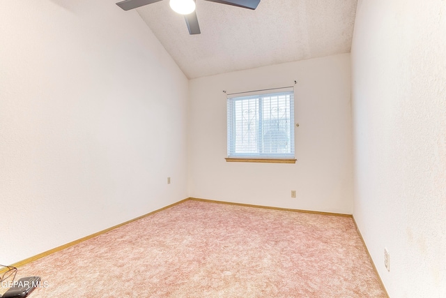 empty room featuring ceiling fan, light colored carpet, a textured ceiling, and vaulted ceiling