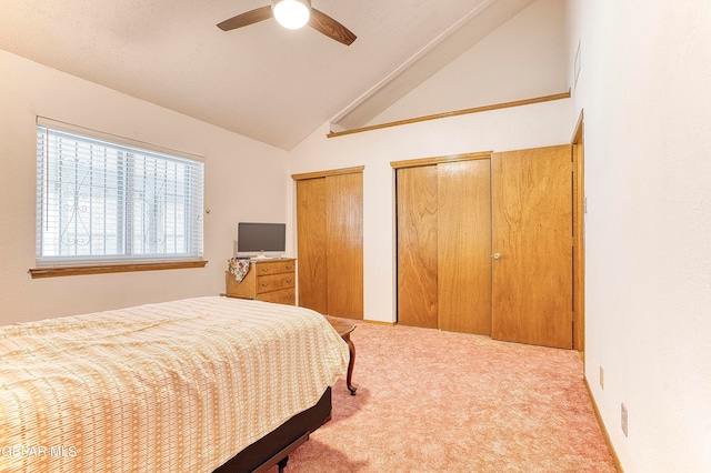 bedroom with high vaulted ceiling, carpet flooring, multiple closets, and ceiling fan