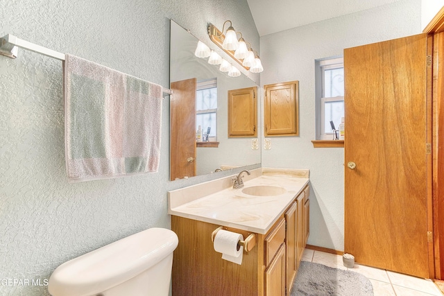 bathroom featuring tile patterned flooring, vanity, a wealth of natural light, and toilet