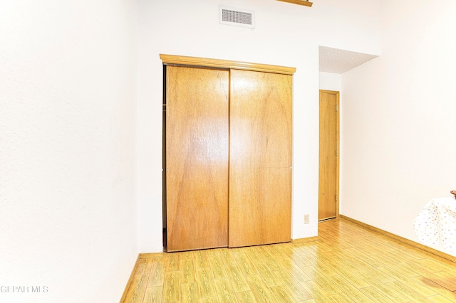 unfurnished bedroom featuring light wood-type flooring and a closet