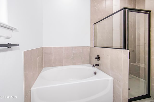 bathroom featuring shower with separate bathtub