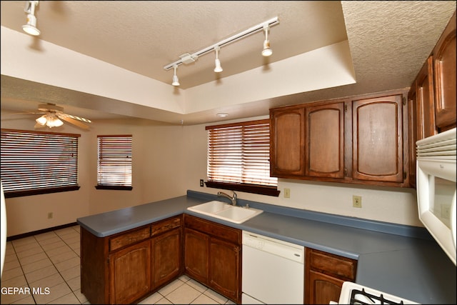 kitchen with ceiling fan, white dishwasher, sink, kitchen peninsula, and rail lighting