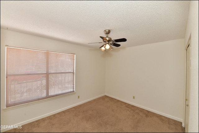 carpeted spare room with ceiling fan and a textured ceiling