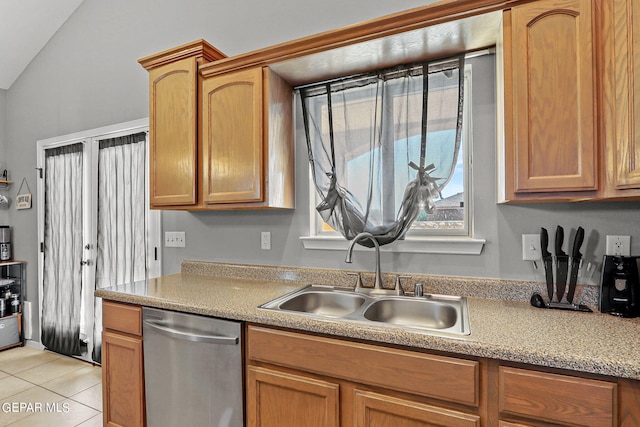 kitchen with dishwasher, lofted ceiling, sink, and light tile patterned floors