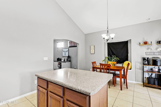 kitchen with a chandelier, a kitchen island, decorative light fixtures, high vaulted ceiling, and light tile patterned floors