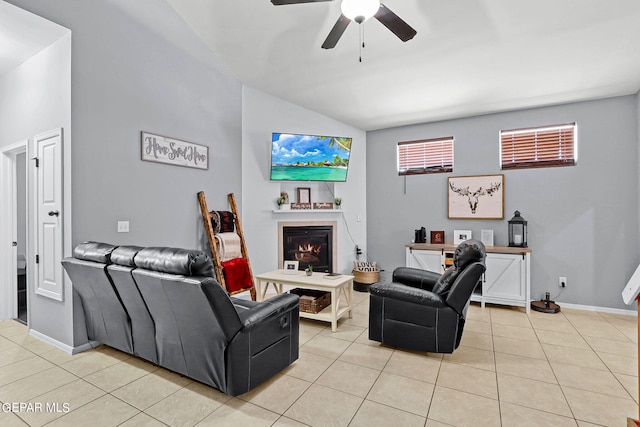 tiled living room featuring plenty of natural light, a fireplace, ceiling fan, and vaulted ceiling