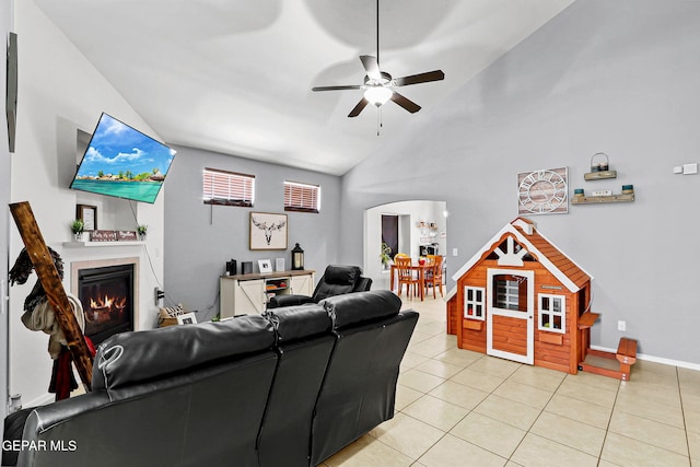 tiled living room featuring high vaulted ceiling and ceiling fan