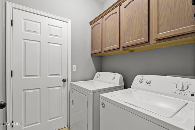 laundry room with washing machine and dryer and cabinets