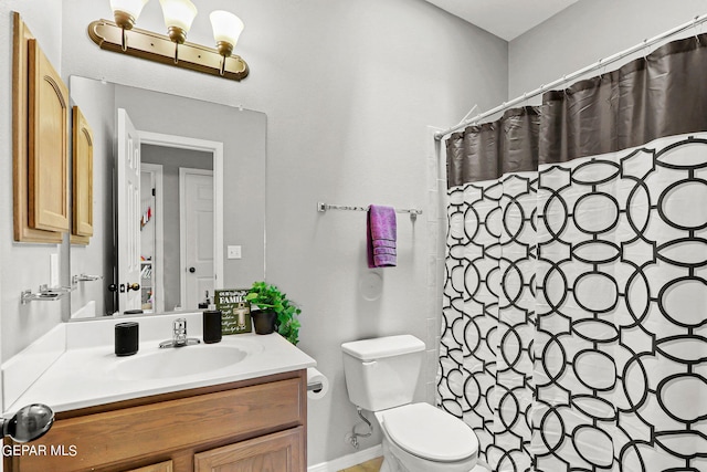 bathroom with walk in shower, vanity, and toilet