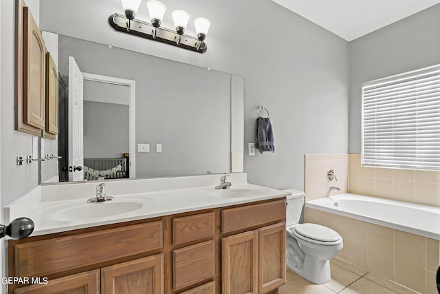 bathroom featuring tile patterned flooring, vanity, tiled tub, and toilet