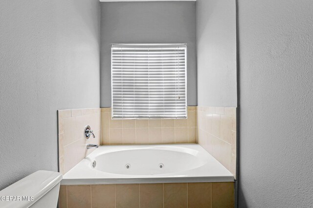 bathroom featuring a relaxing tiled tub and toilet