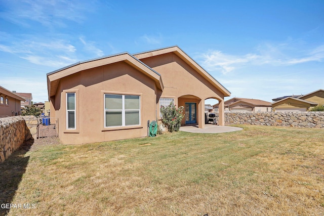 rear view of house with a lawn and a patio area