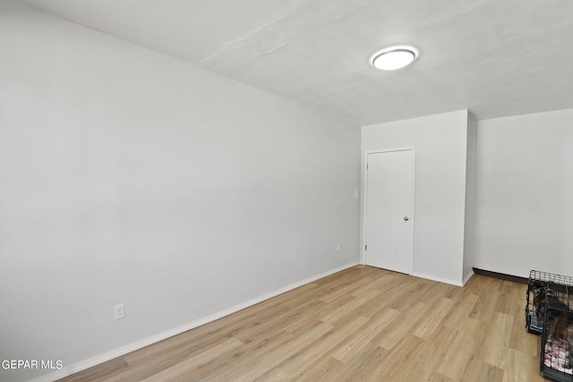 unfurnished room with baseboards and wood finished floors