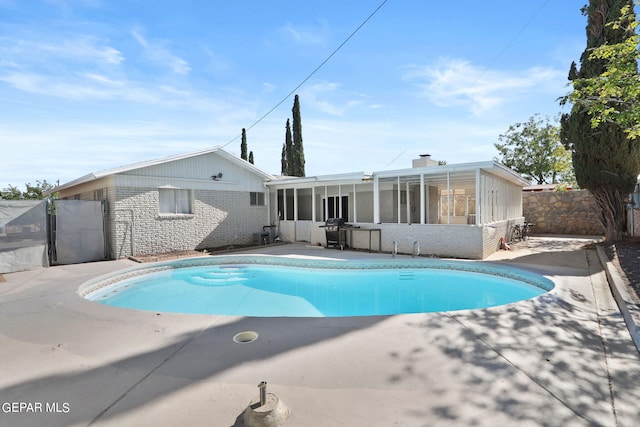 view of pool featuring a sunroom, a patio, a fenced backyard, and a fenced in pool
