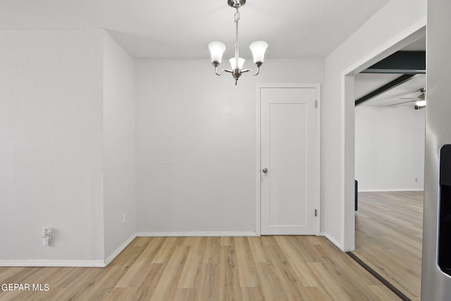 unfurnished dining area featuring light wood-type flooring, baseboards, and ceiling fan with notable chandelier