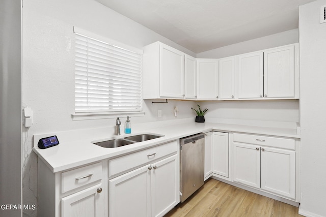 kitchen featuring light countertops, a sink, stainless steel dishwasher, and white cabinets