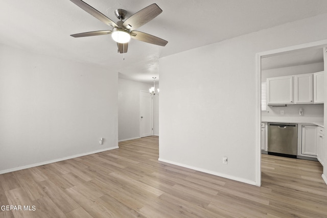 unfurnished living room with light wood-type flooring, baseboards, and ceiling fan with notable chandelier