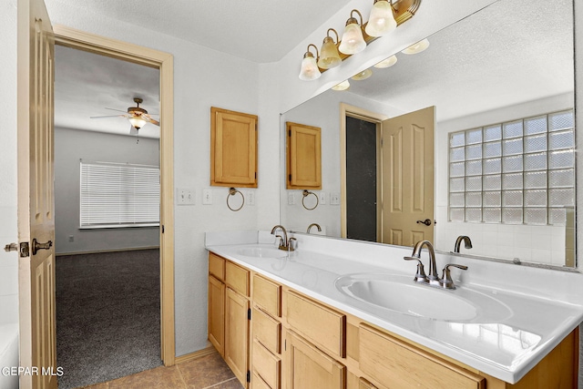 bathroom featuring vanity, a bathtub, a textured ceiling, and tile patterned flooring