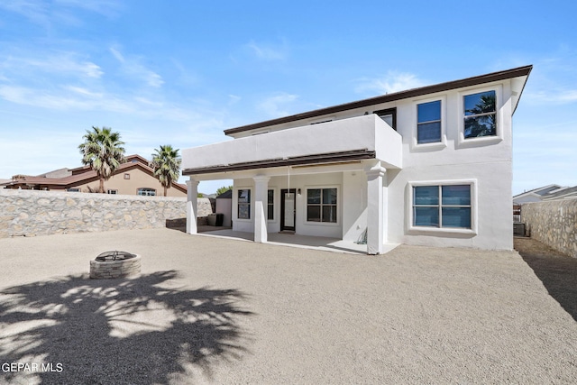 back of property with a patio and a fire pit