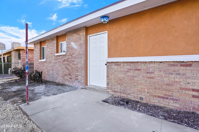 view of exterior entry with a patio