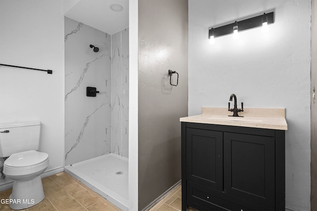 bathroom featuring toilet, tiled shower, and vanity