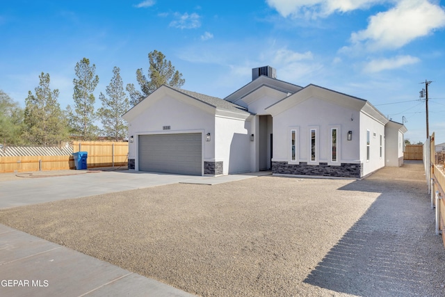 528 Telop Rd, Socorro, TX 79927 - view of front of home featuring an attached garage, stone siding, fence, concrete driveway, and stucco siding