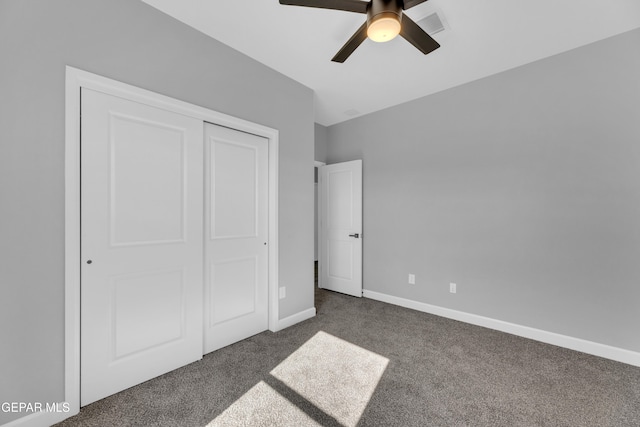 unfurnished bedroom with ceiling fan, a closet, and dark carpet