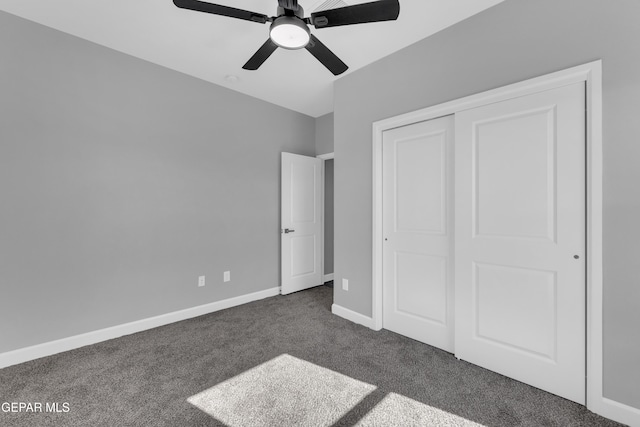 unfurnished bedroom with ceiling fan, a closet, and dark colored carpet