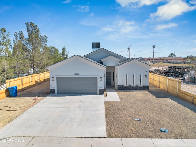 528 Telop Rd, Socorro, TX 79927 - view of front of home featuring stucco siding, fence, stone siding, an attached garage, and concrete driveway