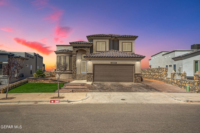 mediterranean / spanish-style home featuring central air condition unit and a garage