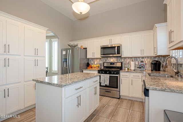 kitchen featuring appliances with stainless steel finishes, sink, a center island, and a healthy amount of sunlight