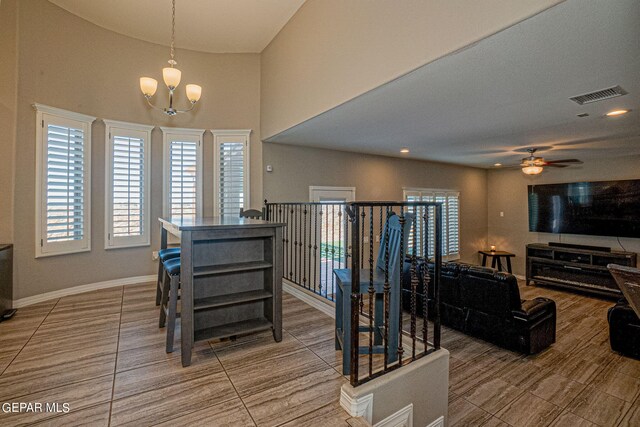 interior space with ceiling fan with notable chandelier