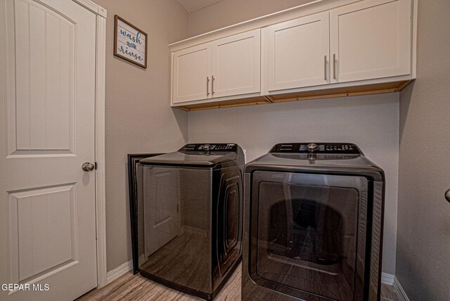 clothes washing area featuring light hardwood / wood-style floors, cabinets, and separate washer and dryer