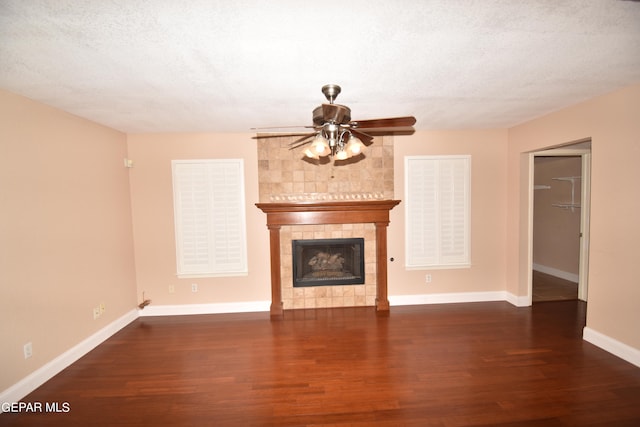 unfurnished living room featuring dark wood-type flooring, a textured ceiling, and a fireplace