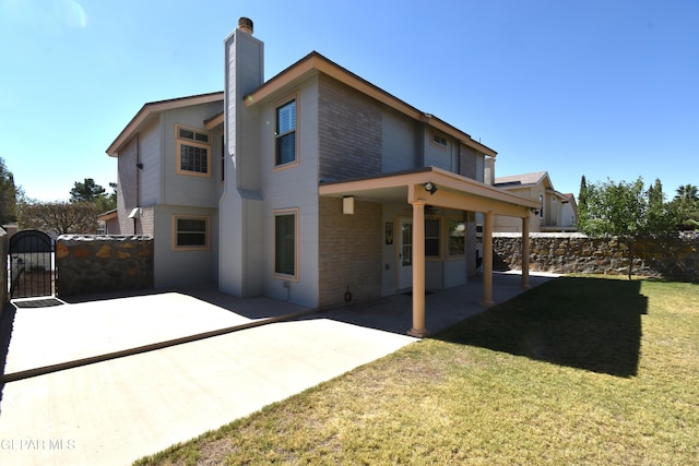 back of property featuring a patio and a lawn