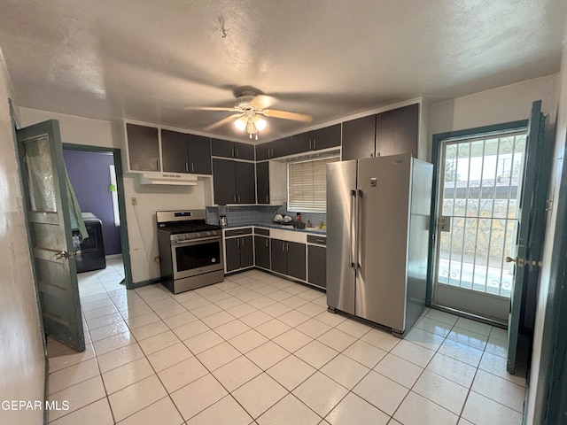 kitchen with stainless steel appliances, ceiling fan, light tile patterned floors, a textured ceiling, and tasteful backsplash