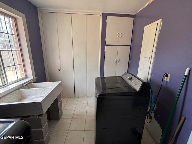 washroom featuring cabinets, washing machine and dryer, and light tile patterned floors