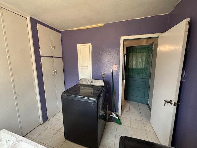 clothes washing area featuring washer / dryer and light tile patterned floors