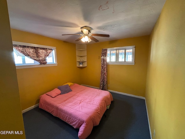 carpeted bedroom with ceiling fan, a textured ceiling, and multiple windows