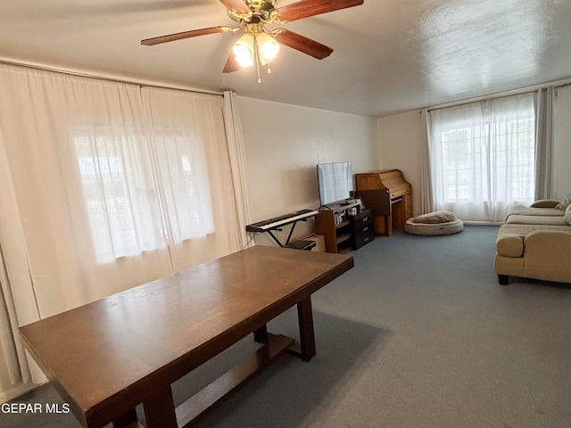 carpeted dining space with ceiling fan