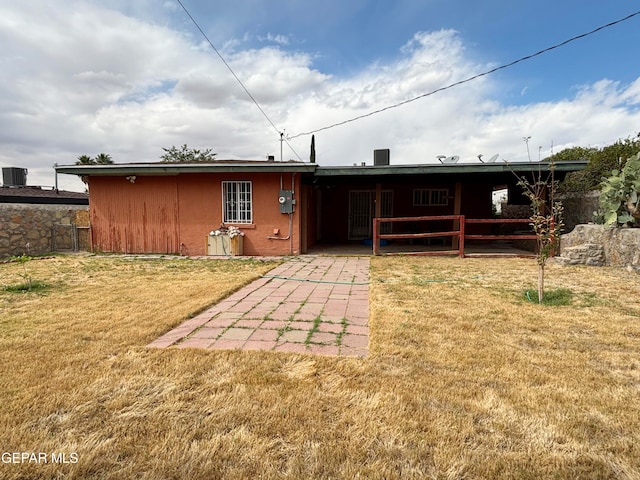 rear view of property featuring a patio area and a yard