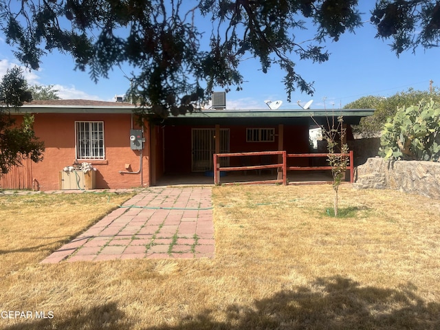 rear view of property featuring a yard, a patio area, and cooling unit