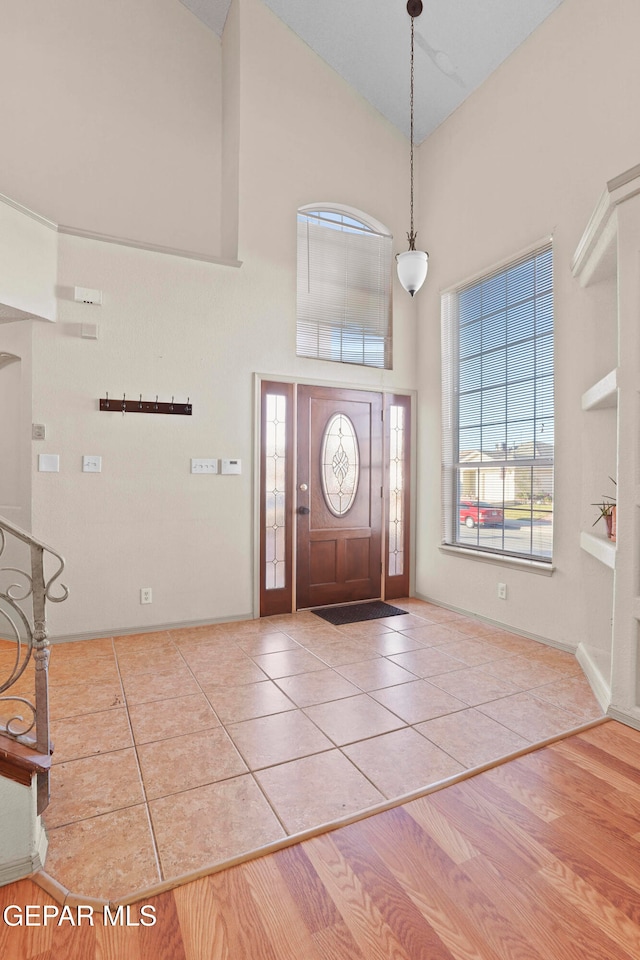 foyer entrance featuring high vaulted ceiling and hardwood / wood-style flooring