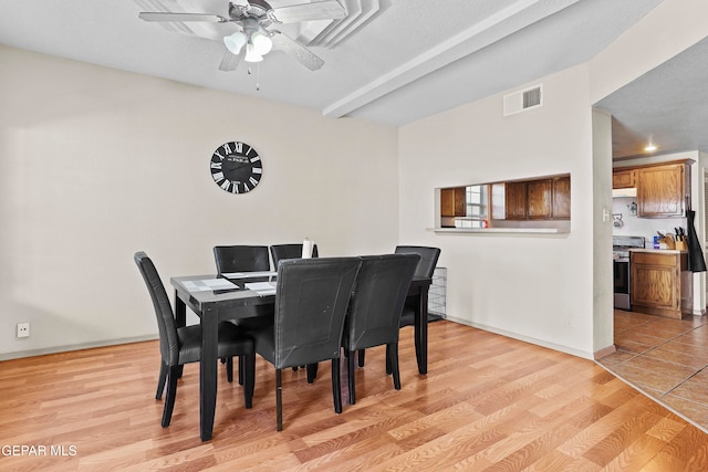 dining room with a textured ceiling, light wood-type flooring, and ceiling fan