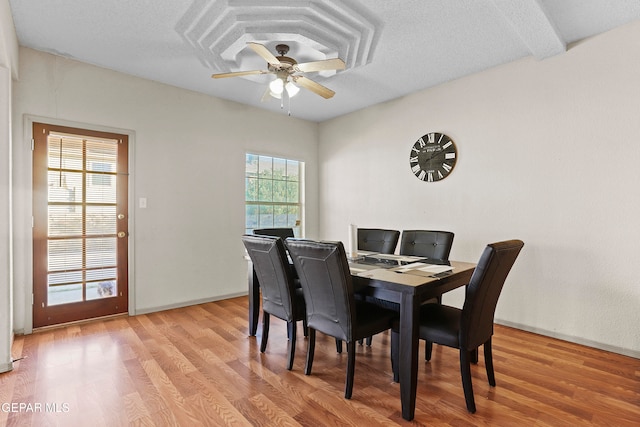 dining space featuring ceiling fan, a textured ceiling, and light wood-type flooring